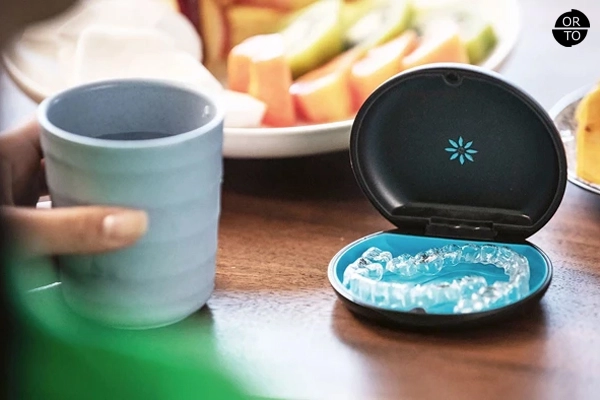 Açık bir saklama kutusunda duran Invisalign şeffaf ortodontik plaklar