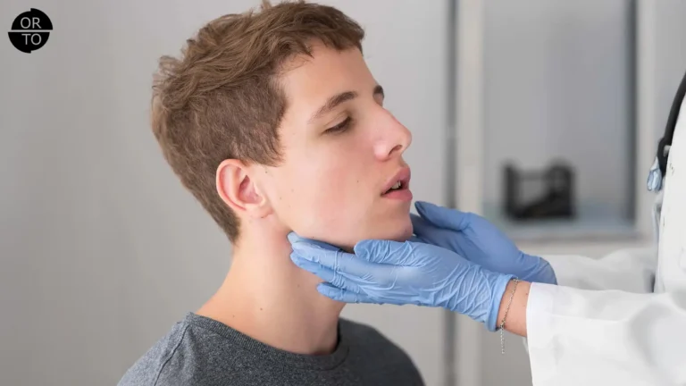 Ortodonti uzmanı tarafından çene muayenesi yapılan genç erkek hasta